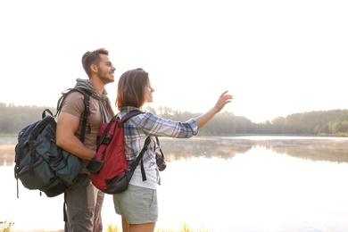 Photo of Young couple on shore of beautiful lake. Camping season