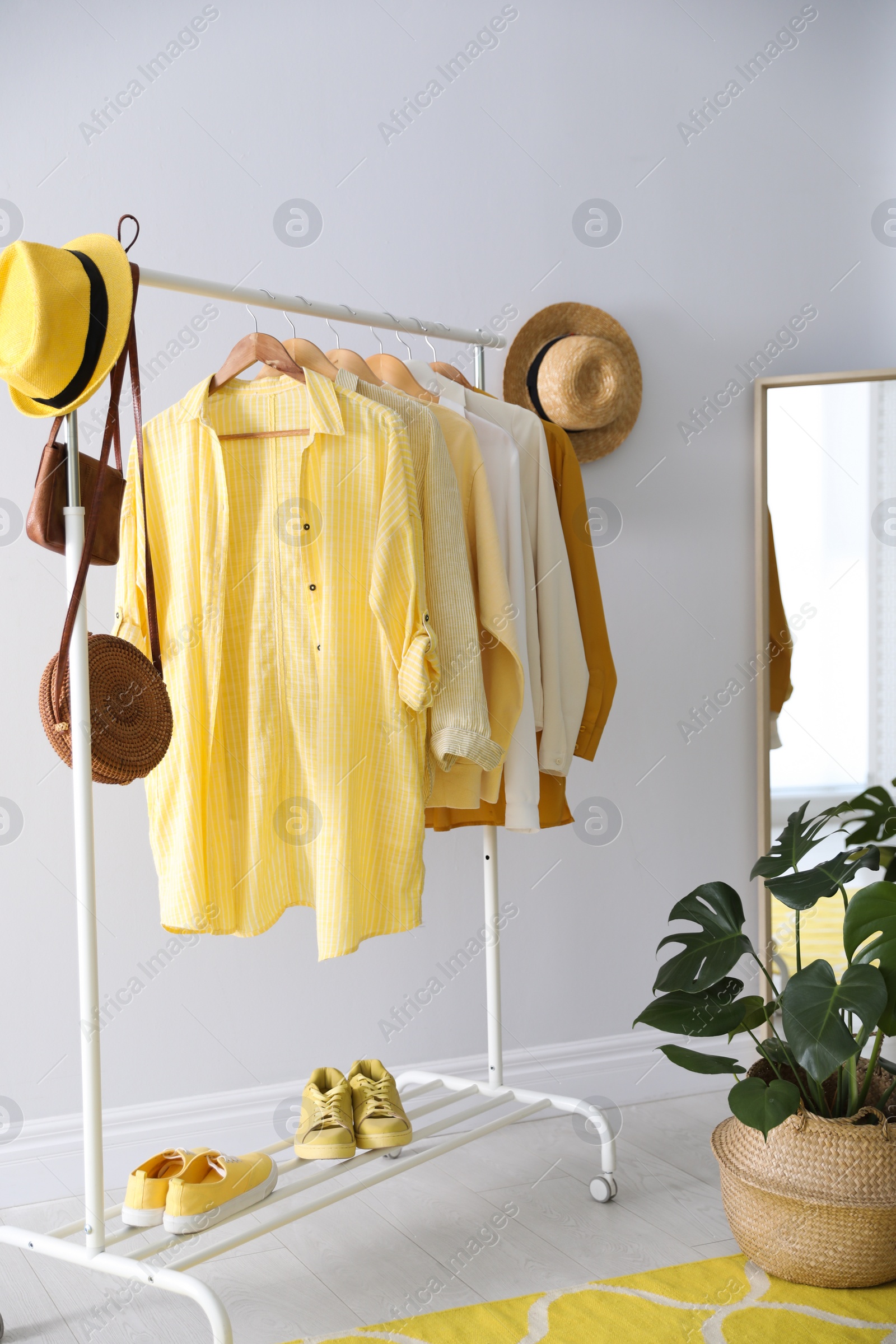 Photo of Rack with stylish women's clothes indoors. Interior design