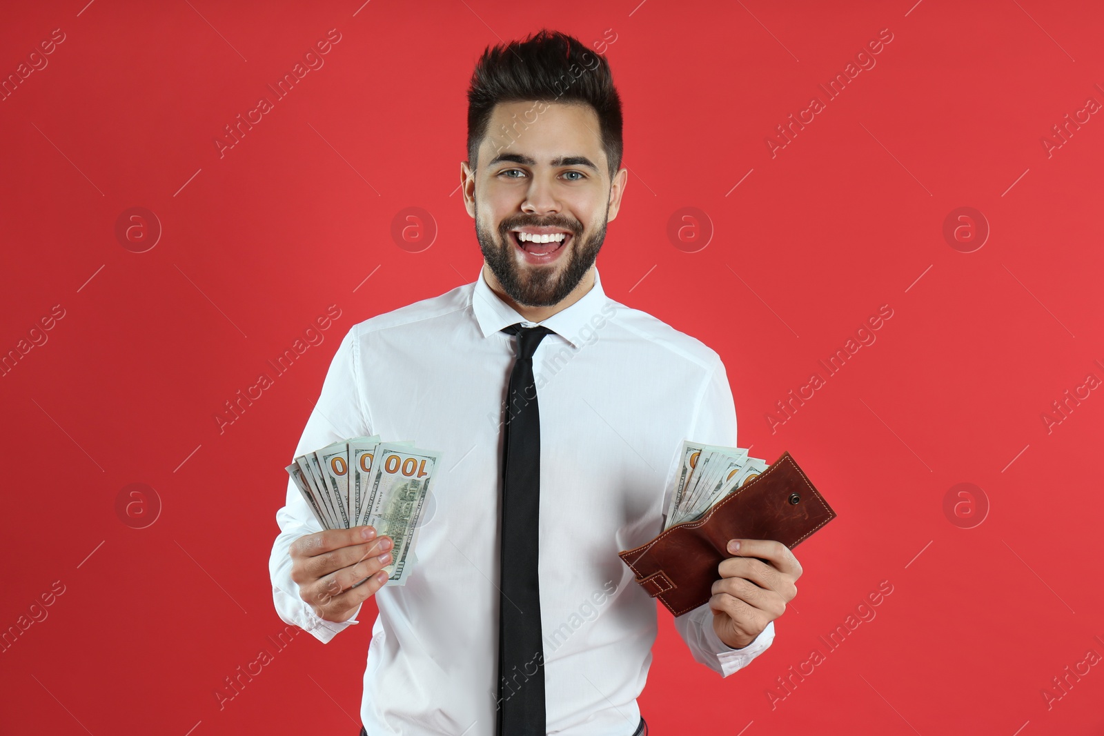 Photo of Emotional young man with money and wallet on crimson background