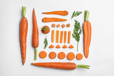 Photo of Tasty ripe carrots and leaves isolated on white, top view