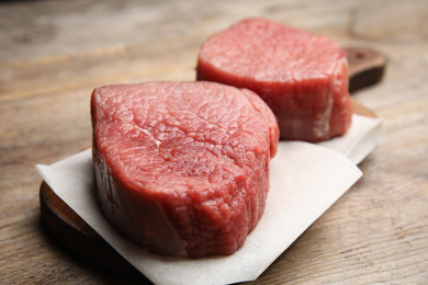 Photo of Fresh raw beef cut on wooden table, closeup