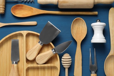 Set of different kitchen utensils on blue wooden table, flat lay