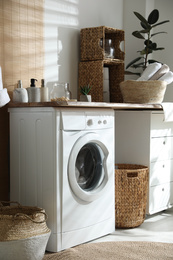 Photo of Stylish bathroom interior with modern washing machine