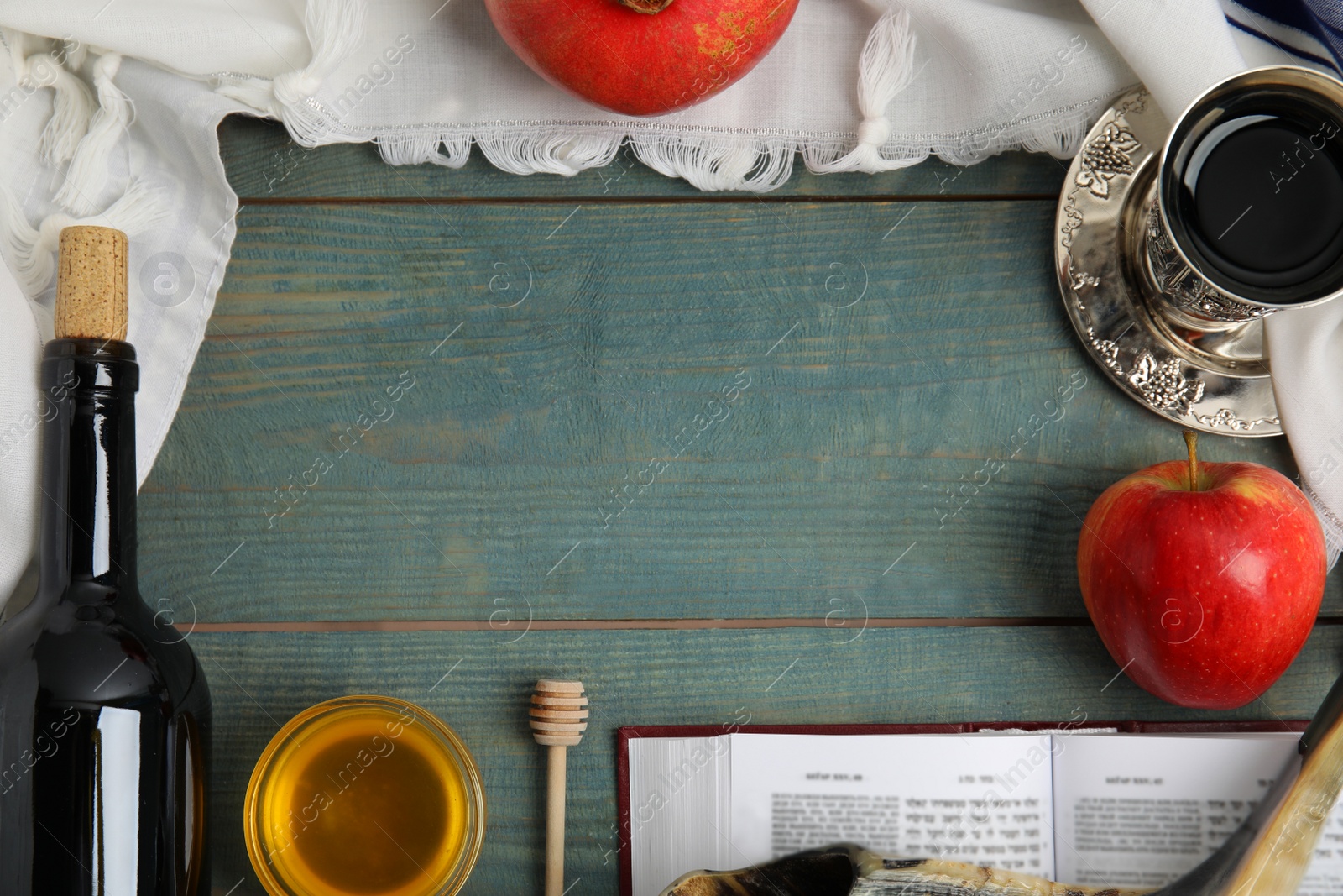 Photo of Frame of Rosh Hashanah holiday attributes on blue wooden table, flat lay. Space for text