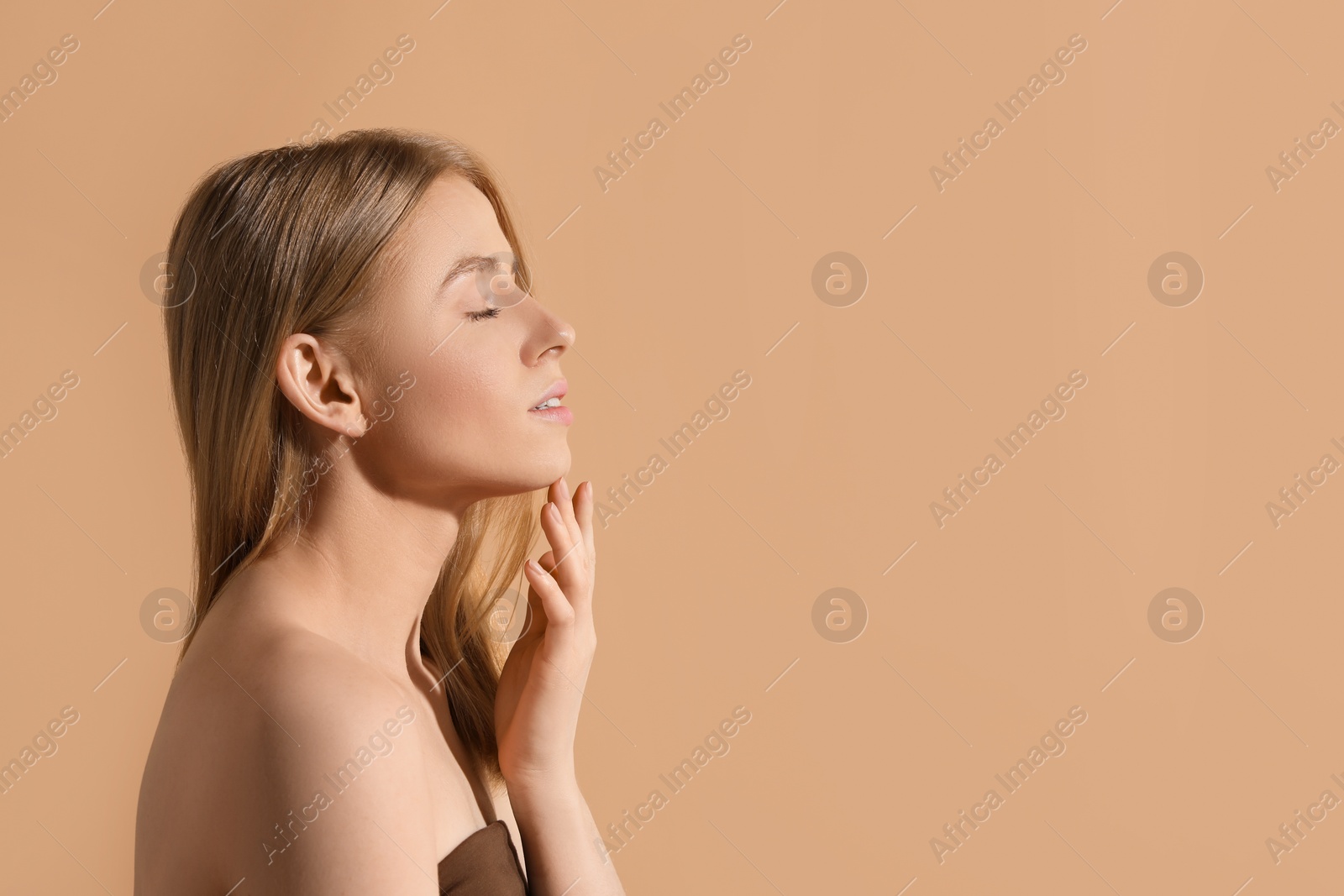 Photo of Beautiful young woman posing on beige background, space for text