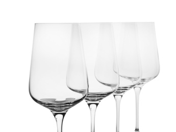 Photo of Empty clear wine glasses on white background