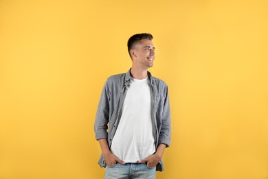 Handsome young man smiling on color background