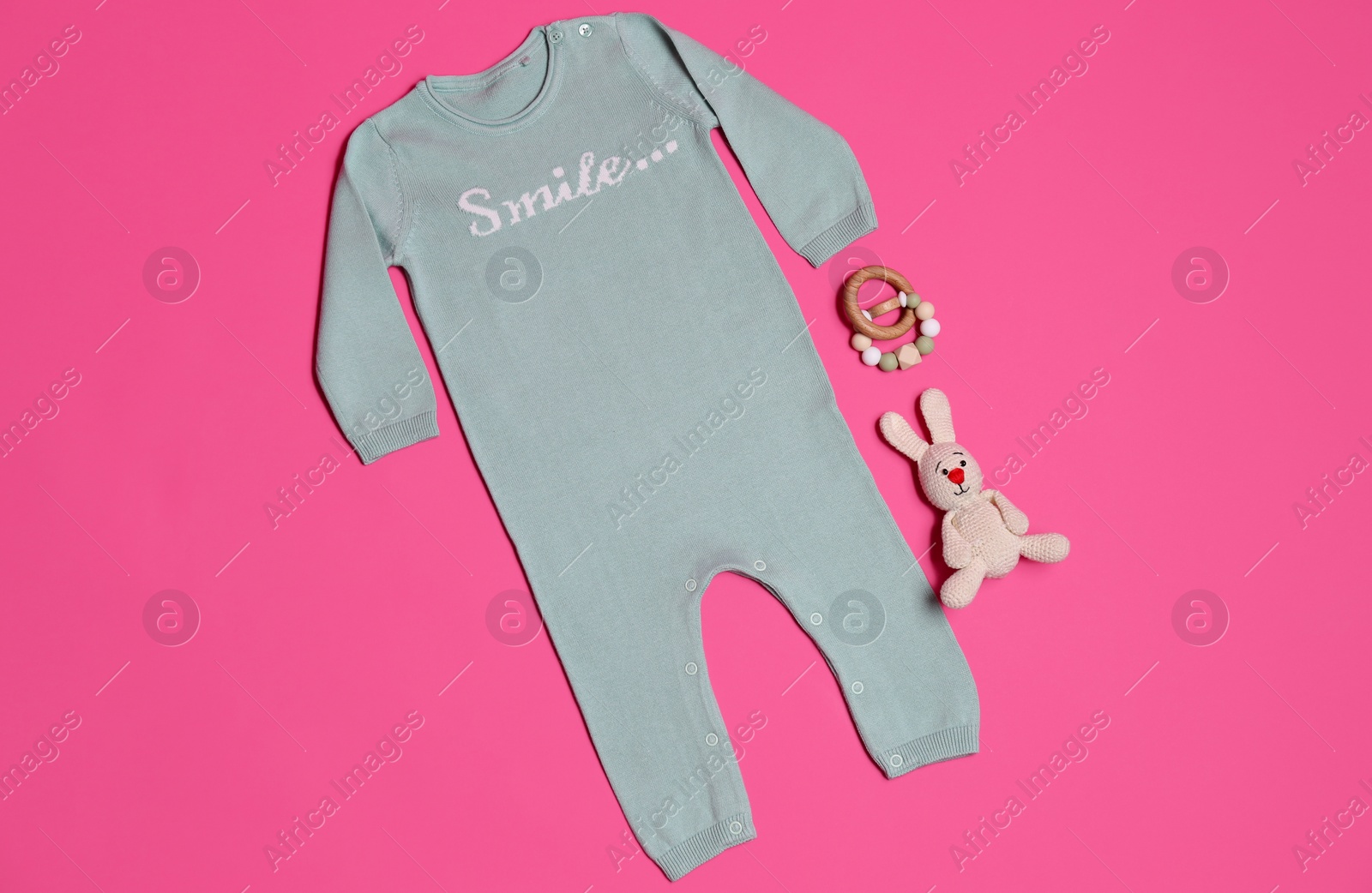 Photo of Baby clothes and toys on pink background, flat lay