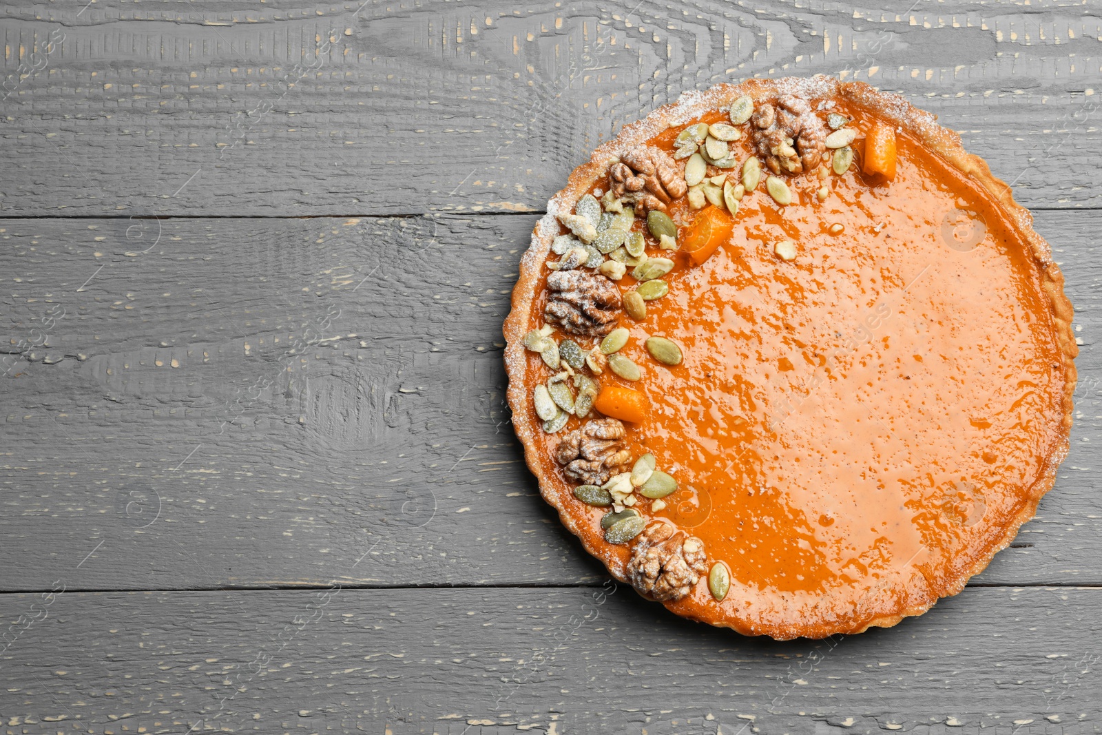 Photo of Delicious fresh homemade pumpkin pie on grey wooden table, top view. Space for text