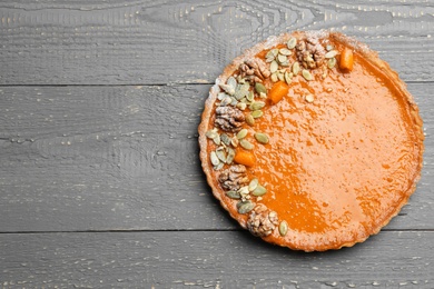 Delicious fresh homemade pumpkin pie on grey wooden table, top view. Space for text