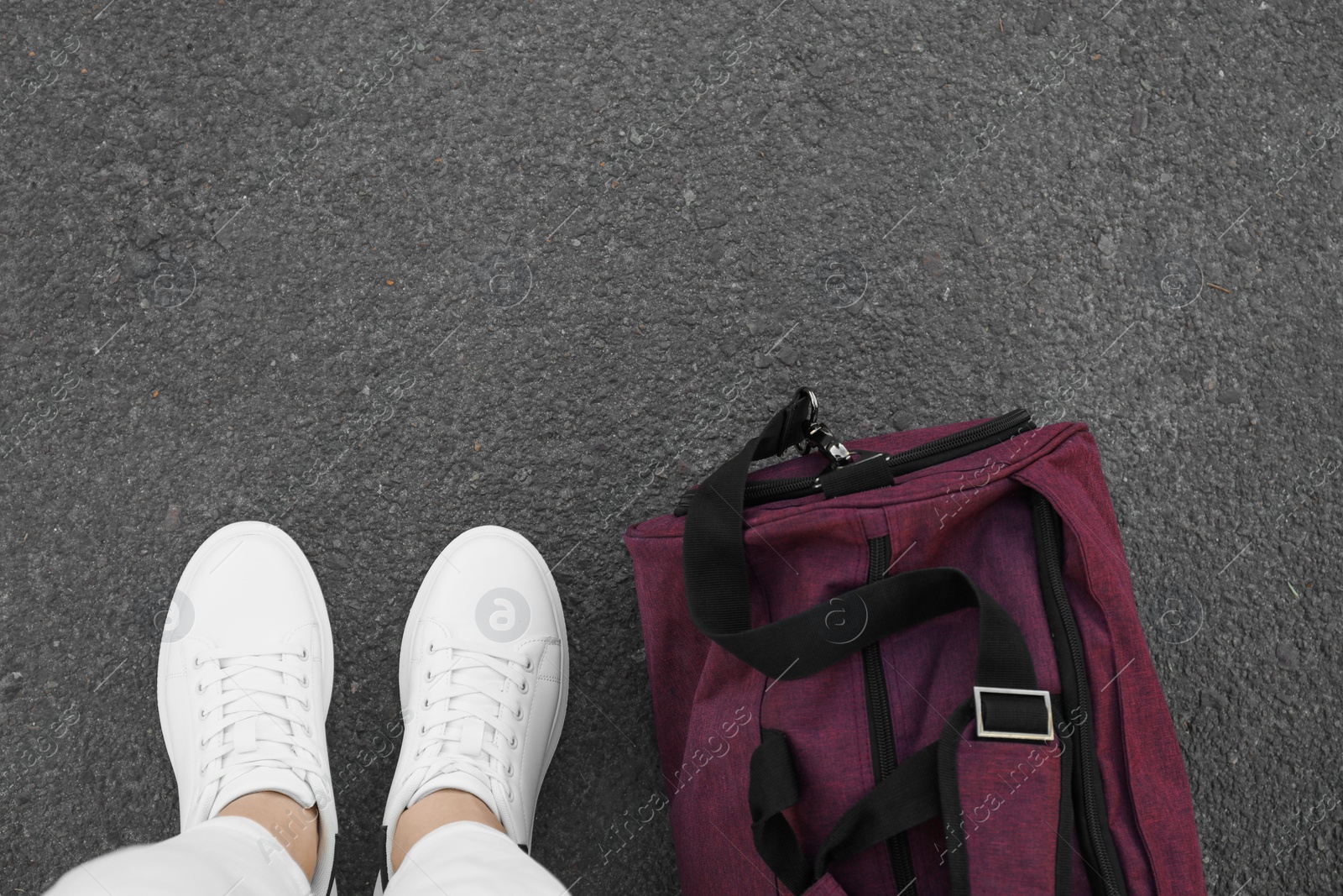 Photo of Woman with bag standing on asphalt, top view