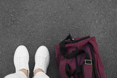 Photo of Woman with bag standing on asphalt, top view