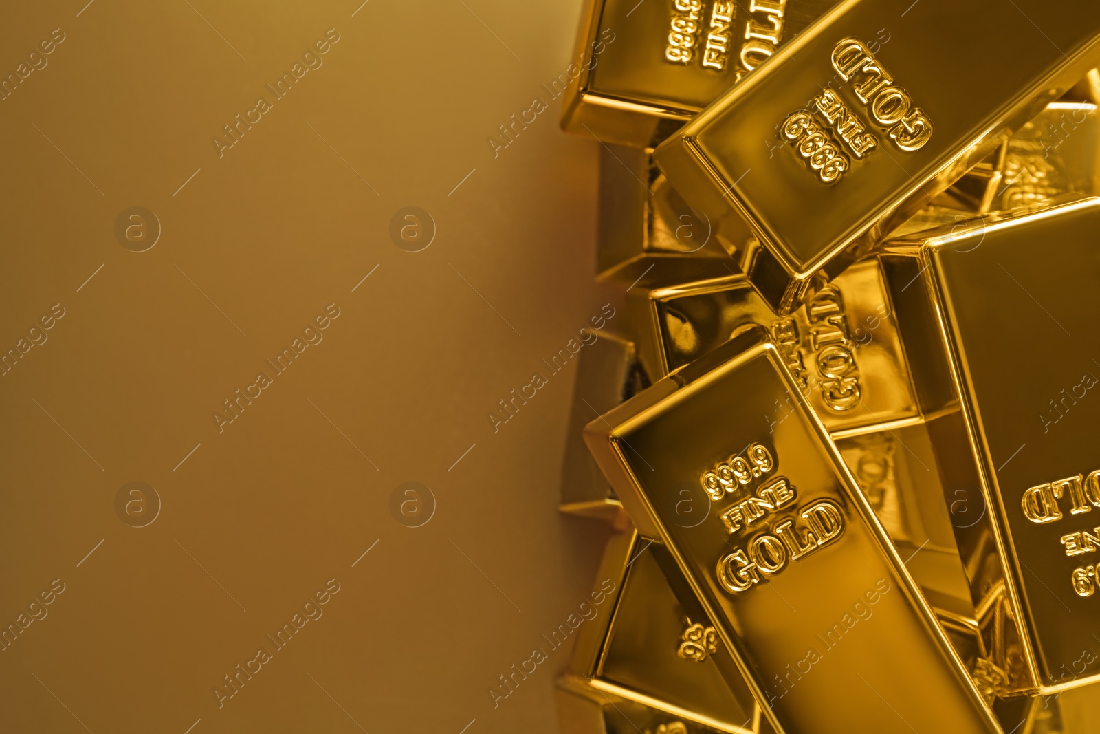 Photo of Many shiny gold bars on color background, flat lay. Space for text