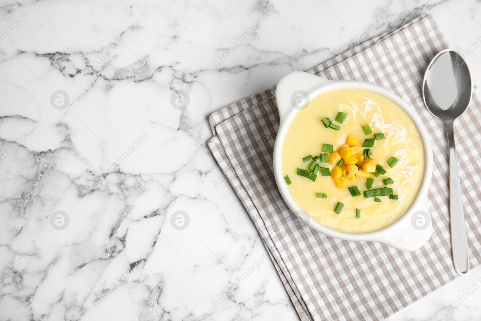 Photo of Delicious corn cream soup served on white marble table, flat lay. Space for text