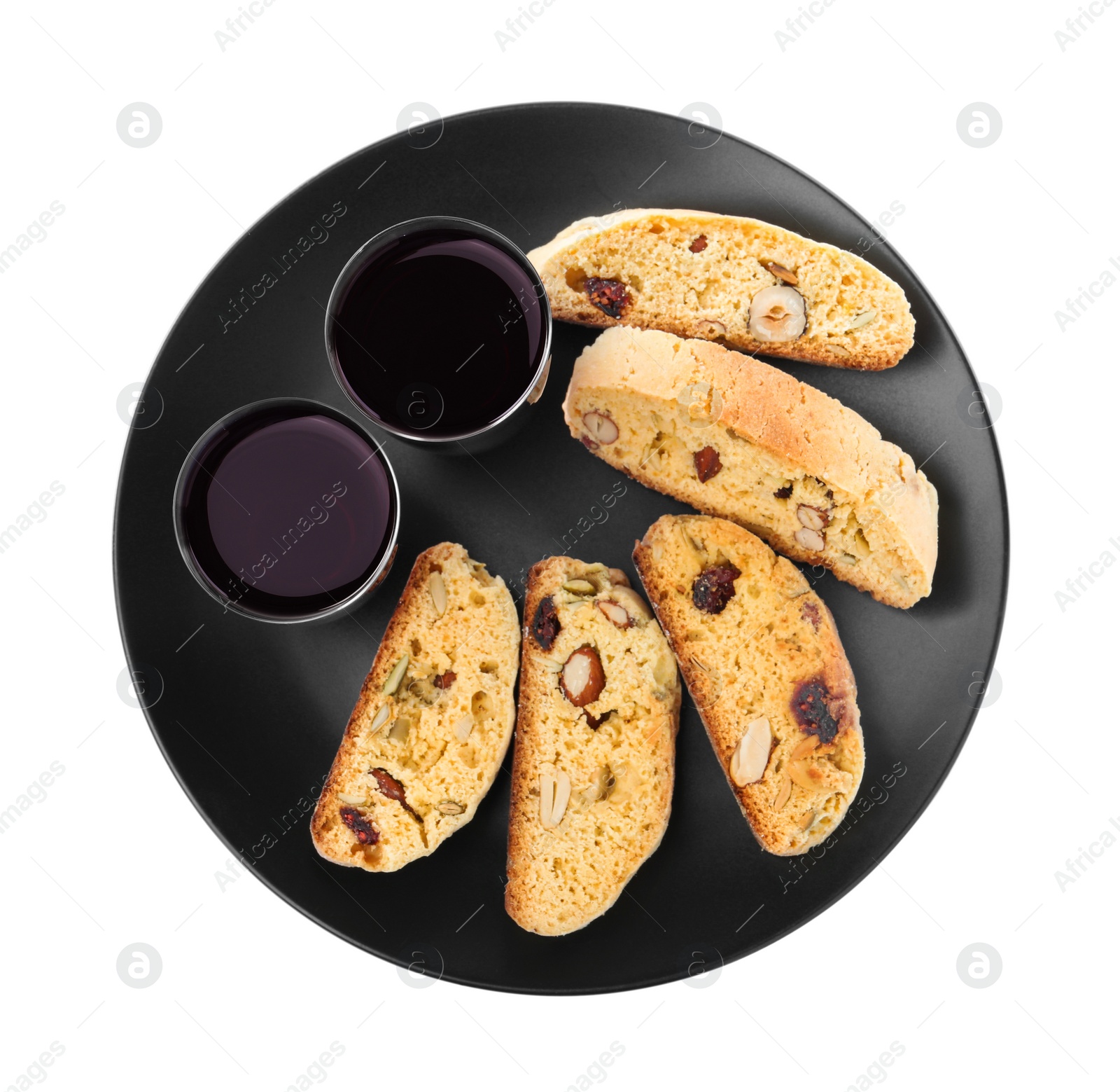 Photo of Black plate with tasty cantucci and glasses of liqueur on white background, top view. Traditional Italian almond biscuits