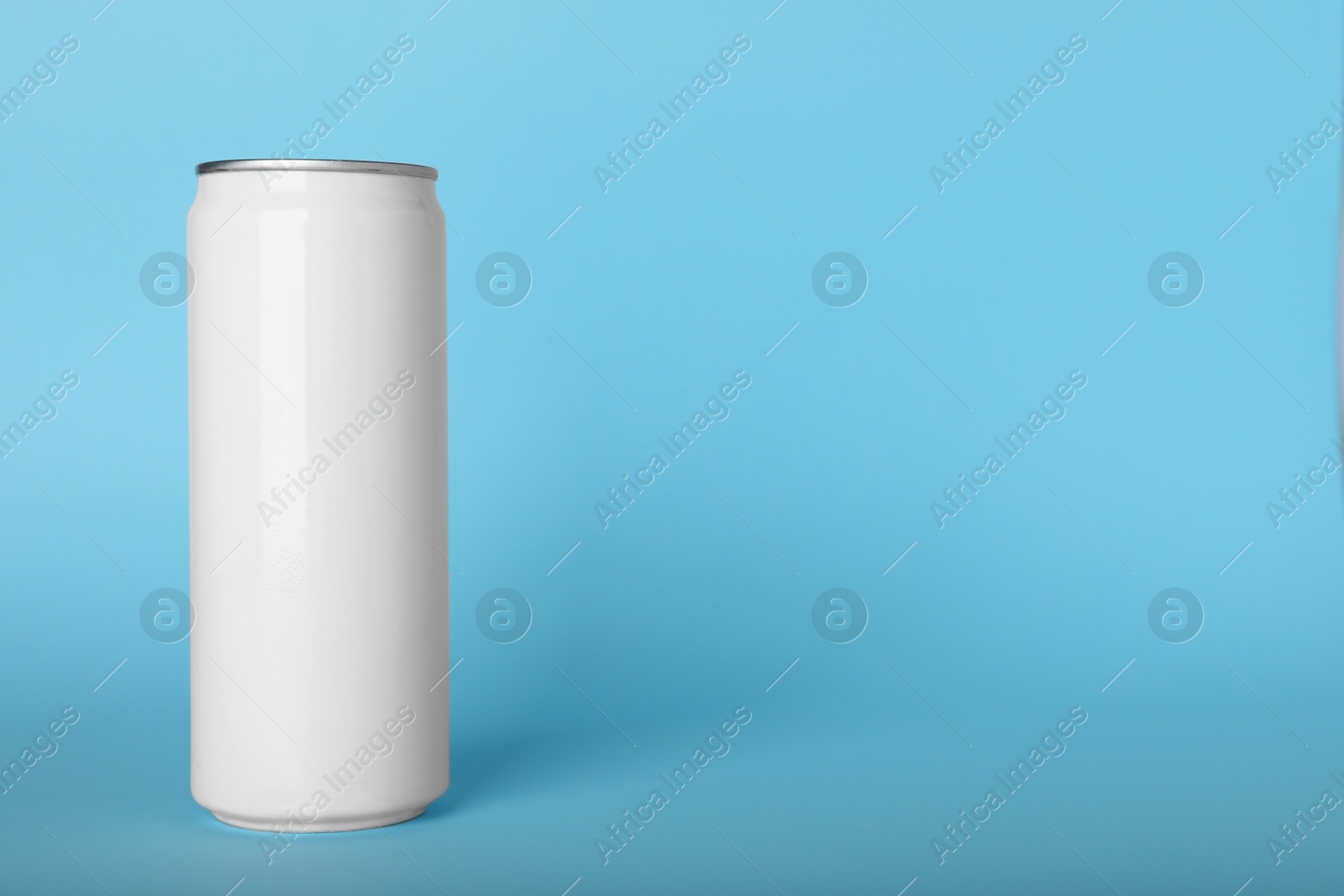 Photo of Can of energy drink on light blue background, space for text