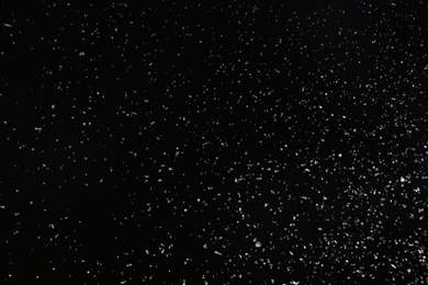 Photo of Snow flakes falling on black background. Winter weather