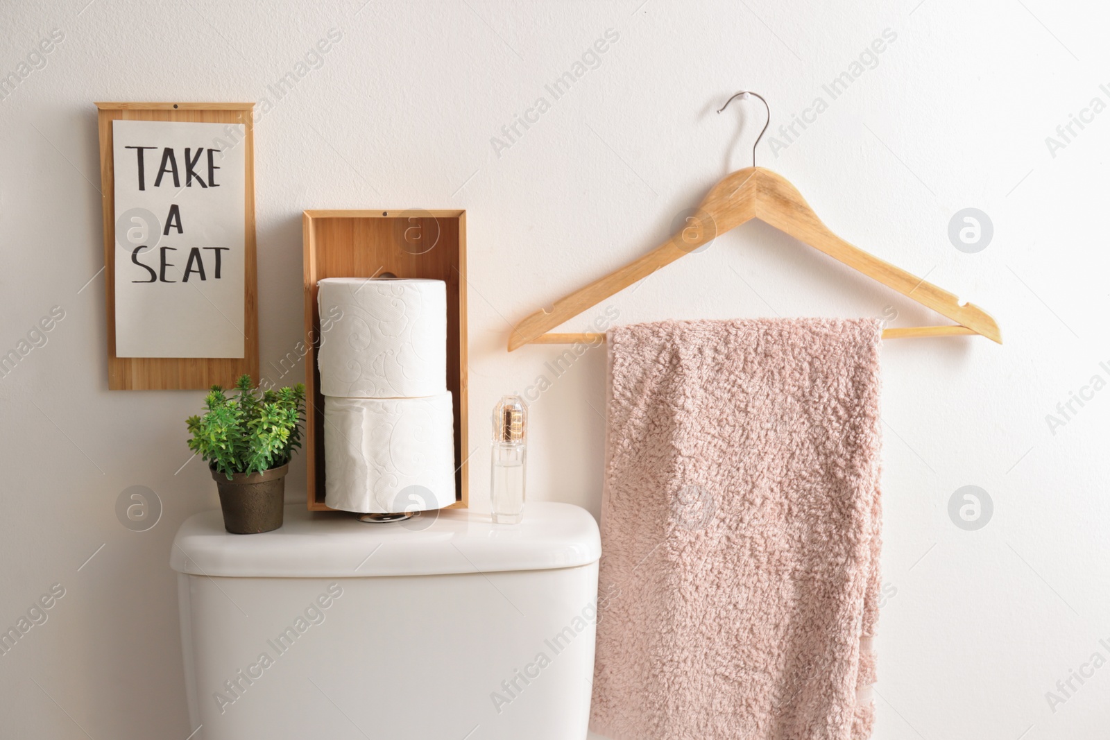 Photo of Decor elements, necessities and toilet bowl near white wall. Bathroom interior