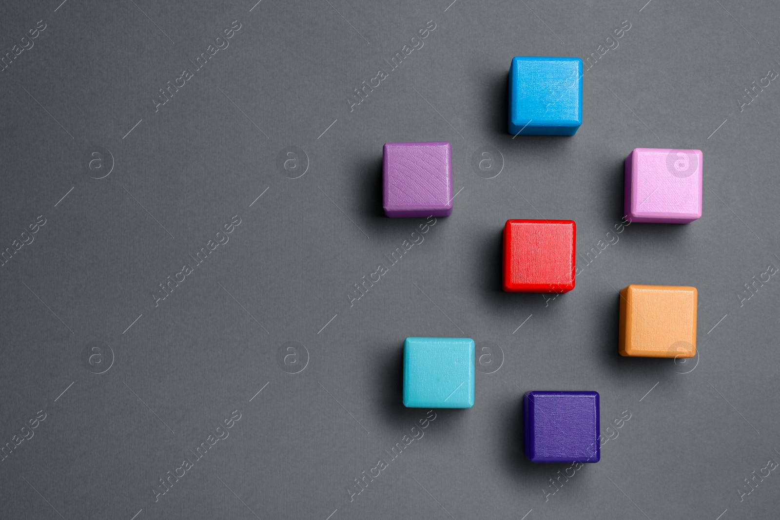 Photo of Blank colorful wooden cubes on dark grey background, flat lay. Space for text