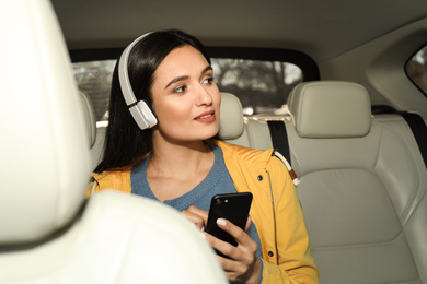 Young woman listening to audiobook in car