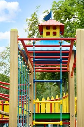 New colorful castle playhouse with climbing frame and rope ladder on children's playground