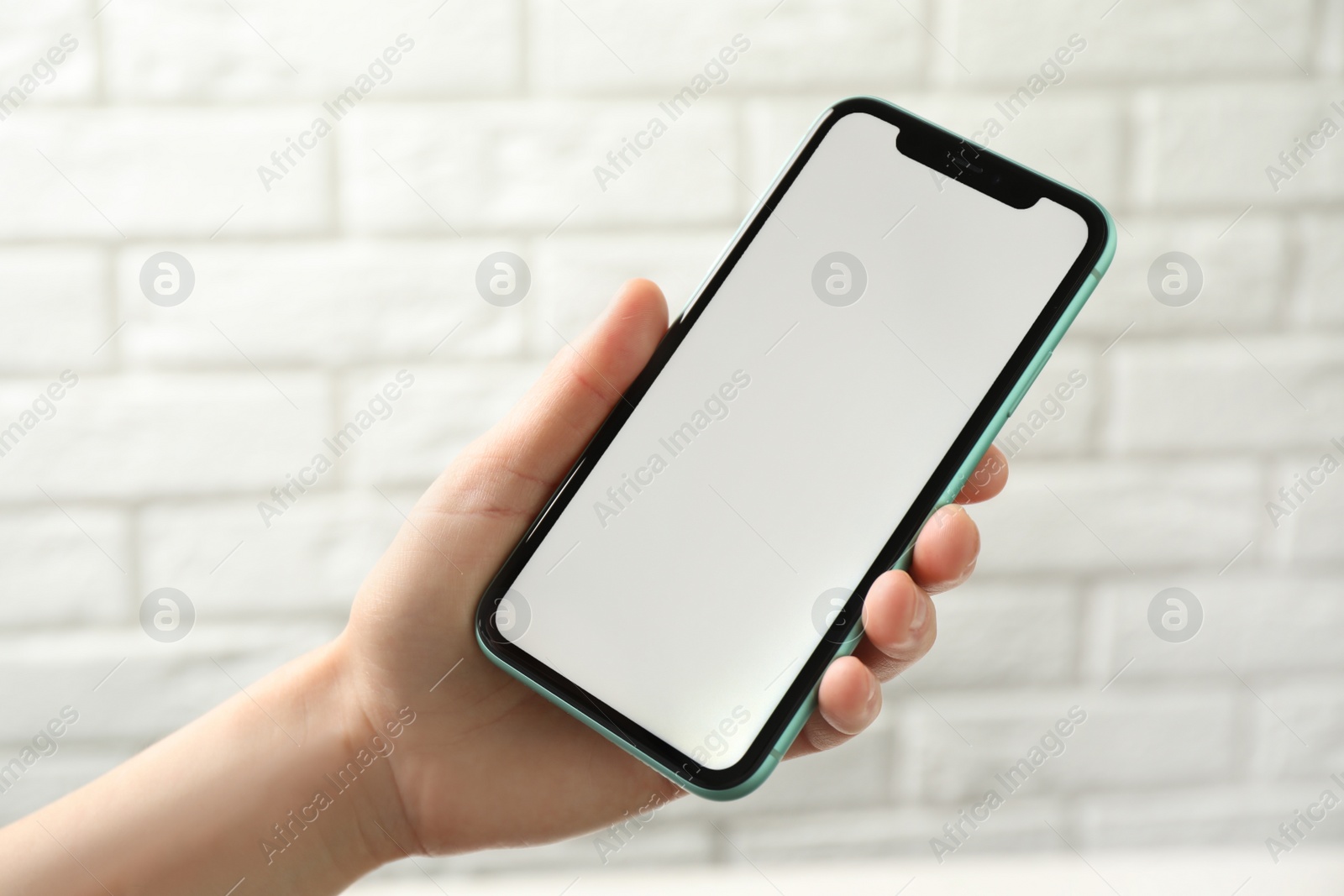 Photo of MYKOLAIV, UKRAINE - JULY 8, 2020: Woman holding Iphone 11 Pro Max with blank screen indoors, closeup