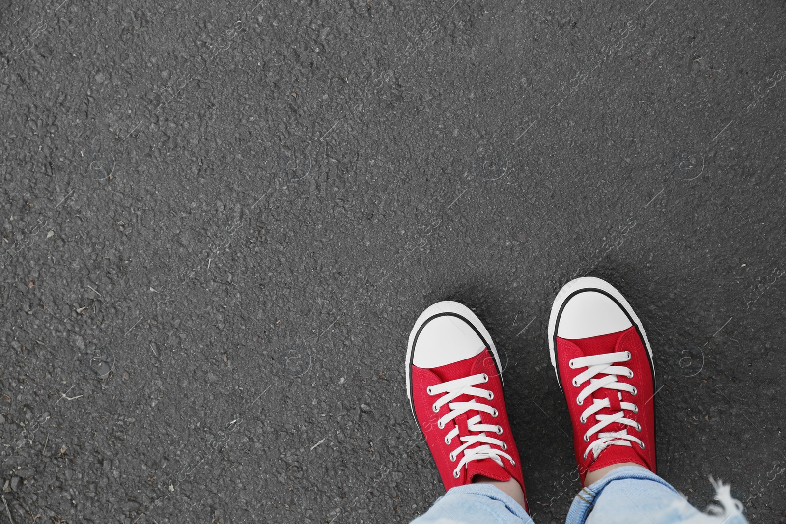 Photo of Woman standing on asphalt, top view. Space for text