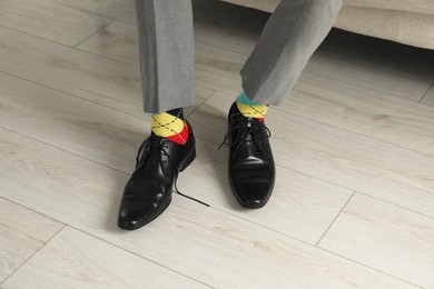 Photo of Man wearing stylish shoes and colorful socks indoors, closeup