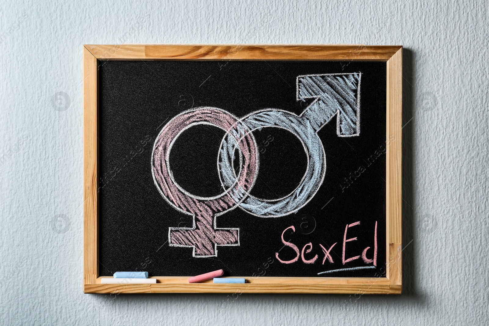 Photo of Gender symbols and text "SEX ED" written on small blackboard