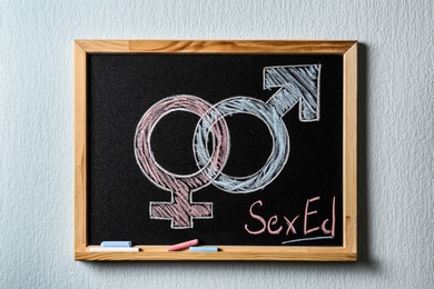 Photo of Gender symbols and text "SEX ED" written on small blackboard