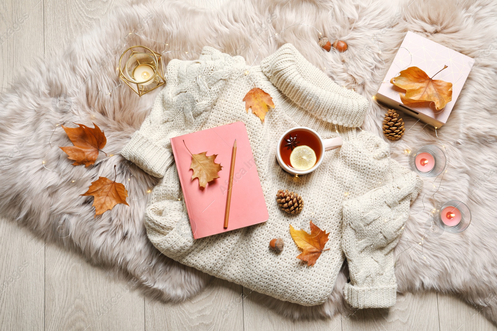 Photo of Flat lay composition with book, cup of tea and warm sweater on fuzzy rug