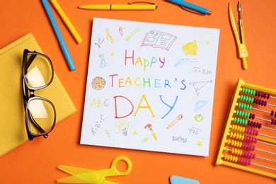 Photo of Paper with inscription HAPPY TEACHER'S DAY, glasses and stationery on orange background, flat lay