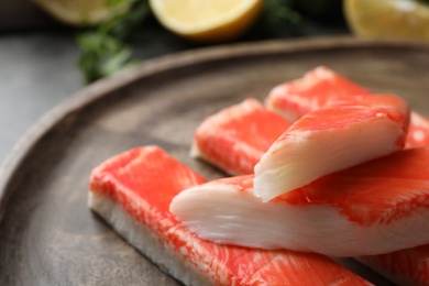 Photo of Delicious crab sticks on wooden board, closeup