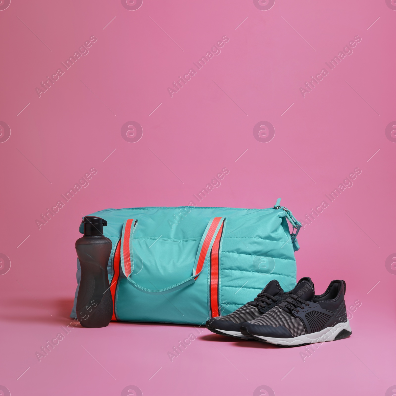 Photo of Blue gym bag and sports accessories on pink background