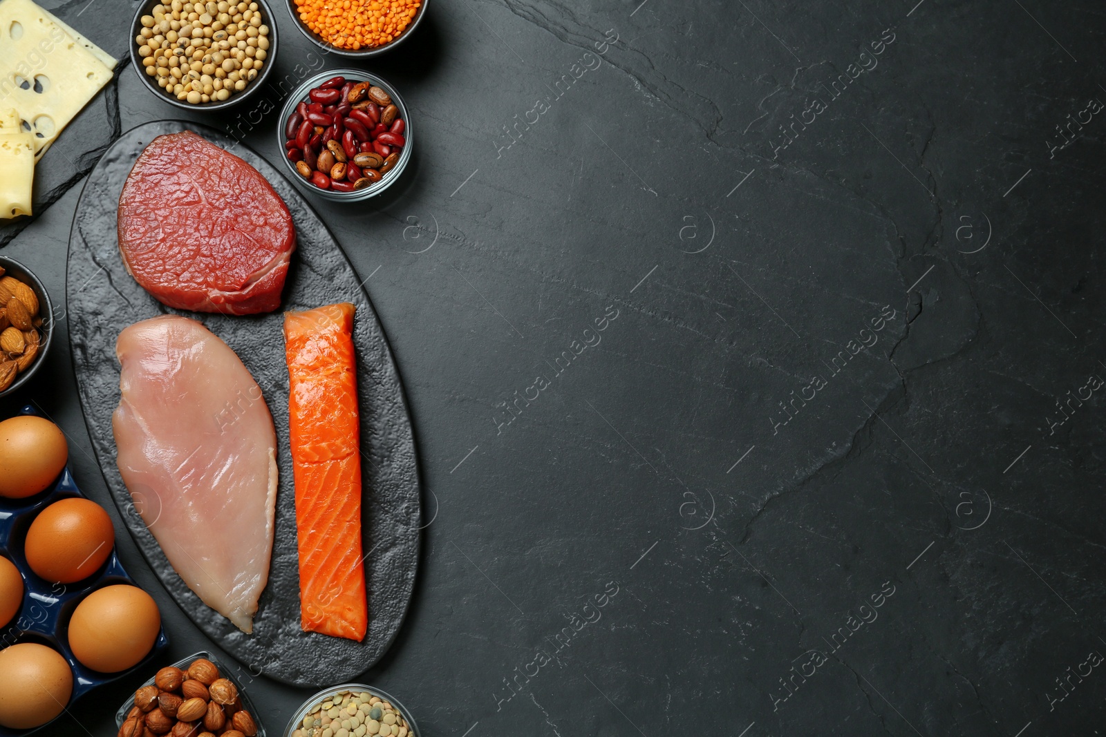 Photo of Different fresh products on black table, flat lay and space for text. Sources of essential amino acids