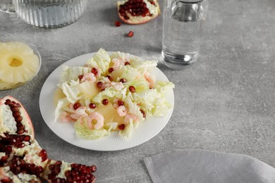 Delicious salad with Chinese cabbage, shrimps and pineapple served on grey table, space for text