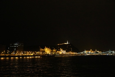 BUDAPEST, HUNGARY - APRIL 27, 2019: Beautiful night cityscape with illuminated buildings along Danube river