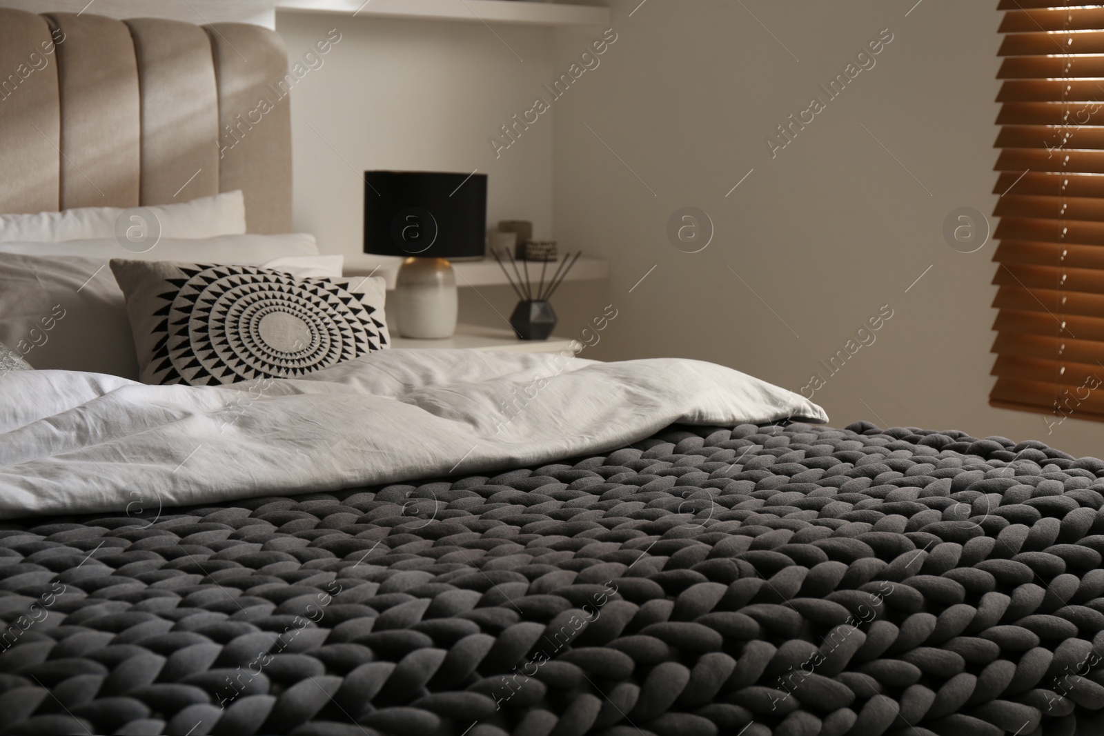 Photo of Soft chunky knit blanket on bed in room