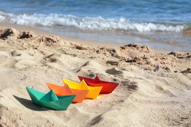 Photo of Many paper boats near sea on sunny day, space for text