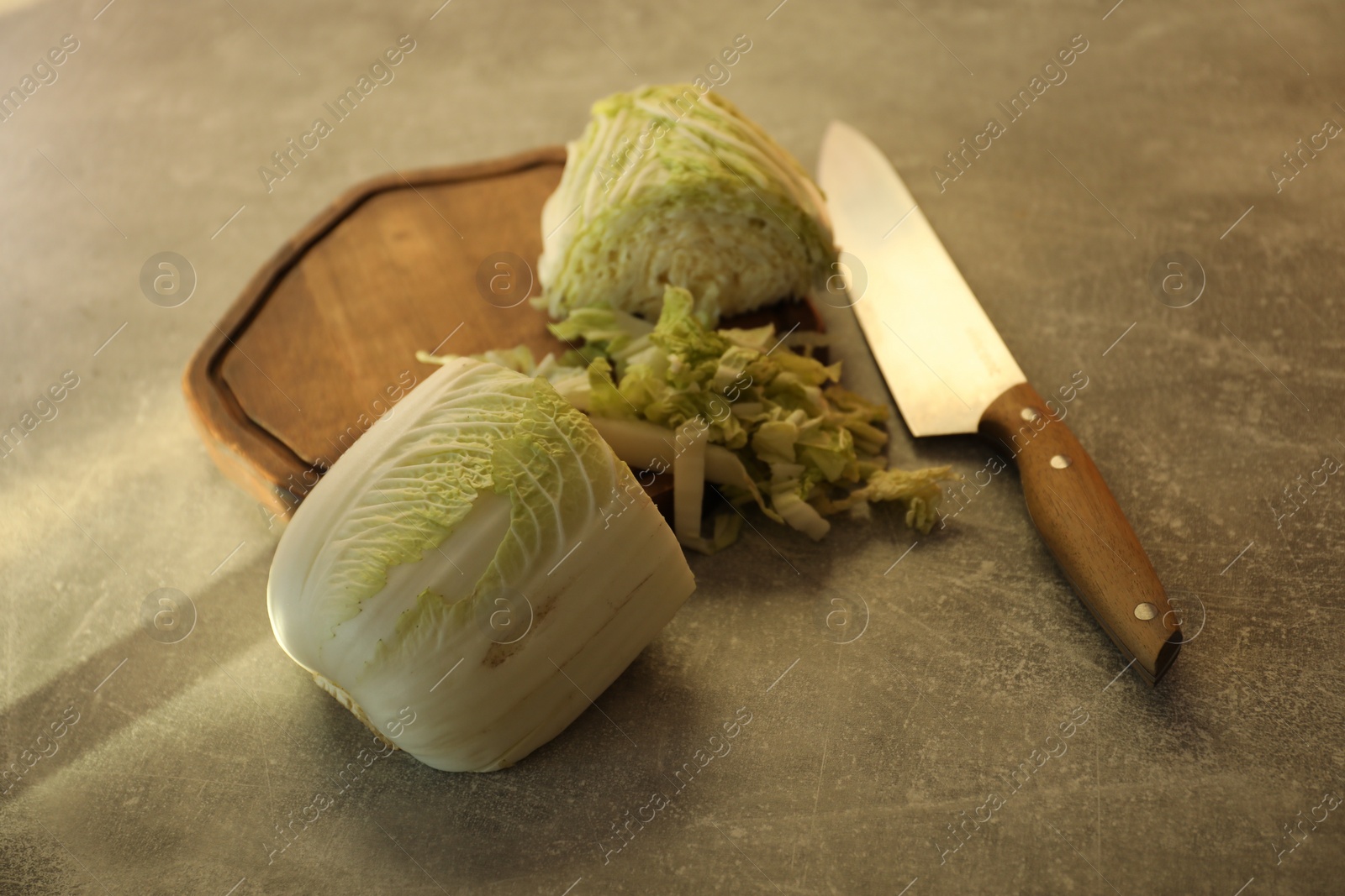 Photo of Cut fresh Chinese cabbage and knife on light grey table