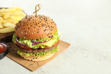 Photo of Burger with delicious patty and french fries on light table, closeup. Space for text