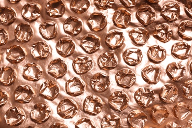 Rose gold bubble wrap as background, top view