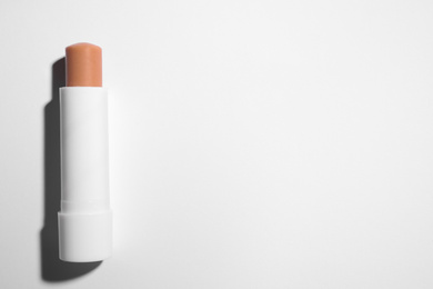 Photo of Hygienic lipstick on white background, top view