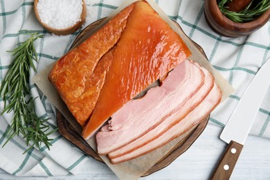 Photo of Delicious smoked bacon with rosemary and salt on white wooden table, flat lay