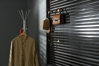 Photo of Rack with clothes and accessories in modern hallway