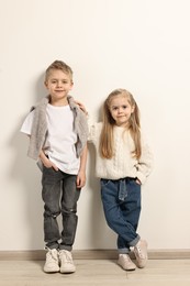 Photo of Fashion concept. Stylish children posing near white wall