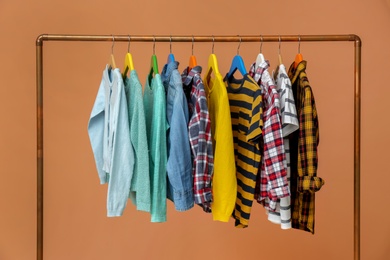 Photo of Rack with stylish children clothes on beige background