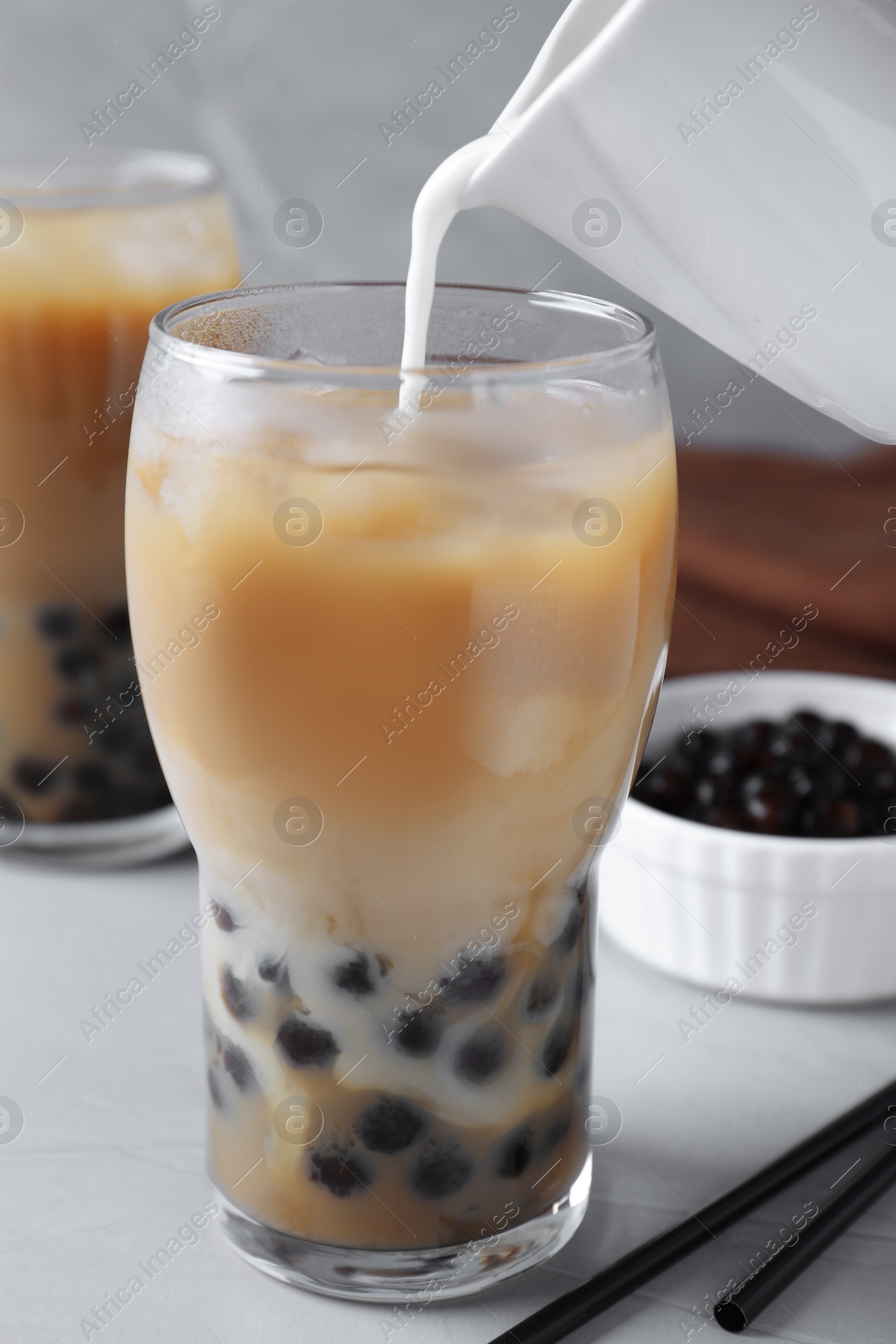 Photo of Preparing bubble milk tea with tapioca balls on table