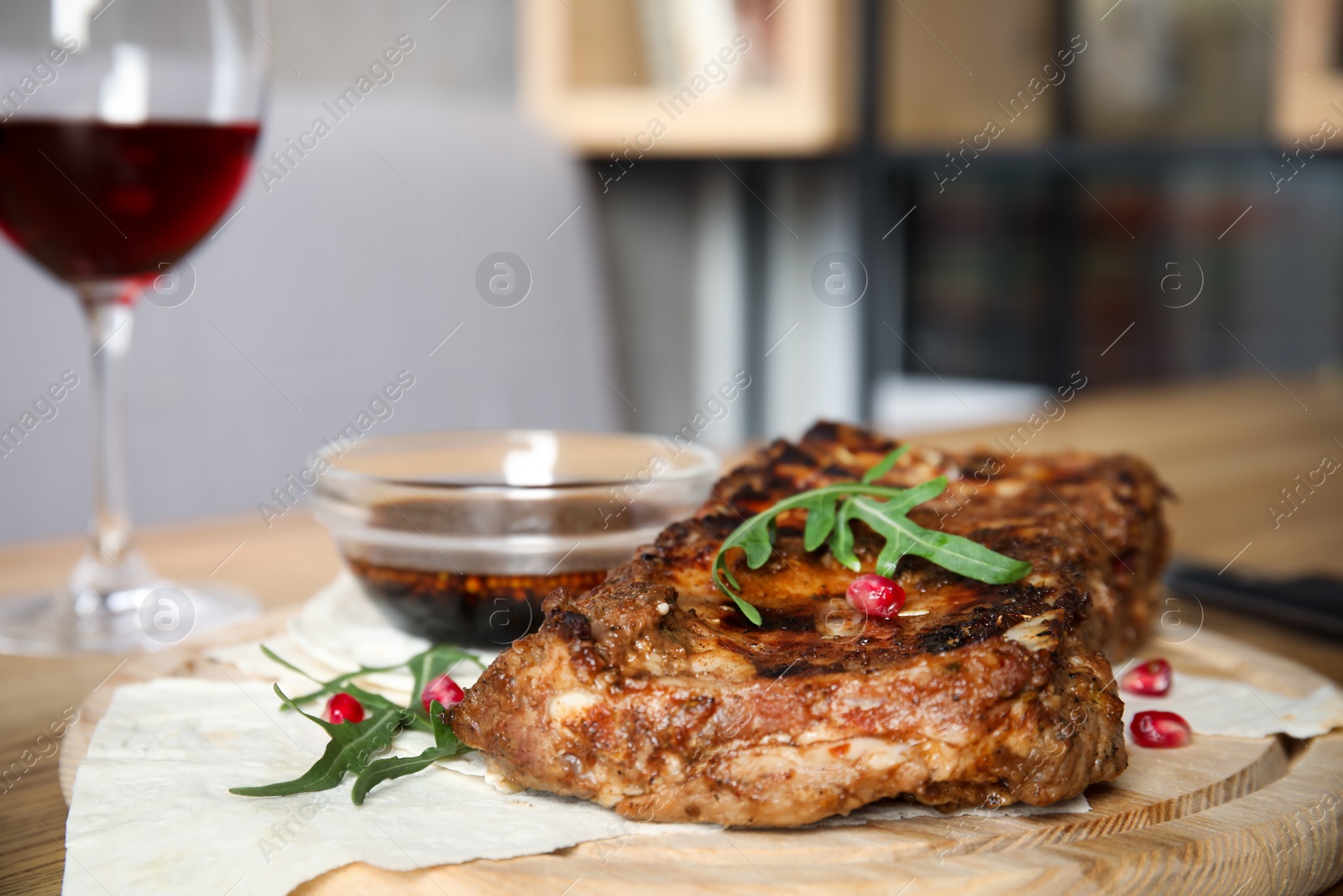 Photo of Delicious grilled ribs on wooden board indoors, closeup