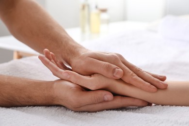 Photo of Woman receiving hand massage in wellness center, closeup
